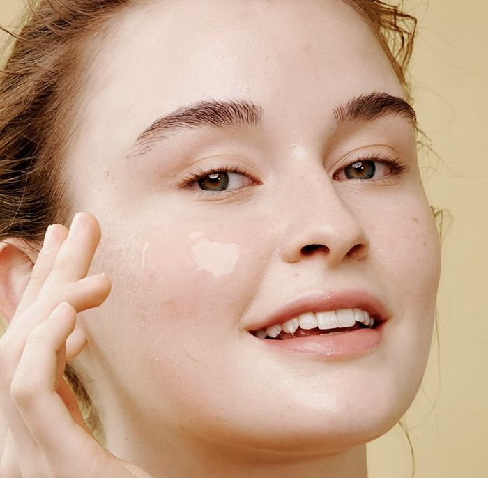 A person applying the essence to their face for a boost of hydration.