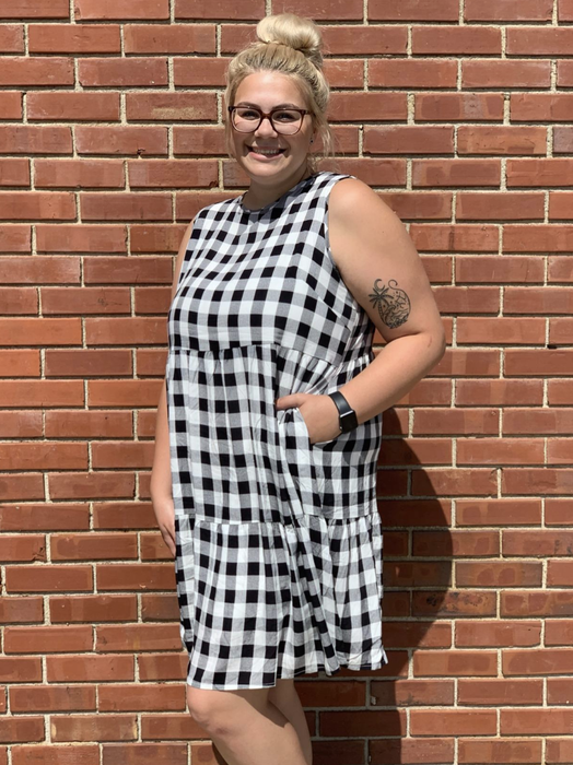 A reviewer showcasing a black and white gingham dress