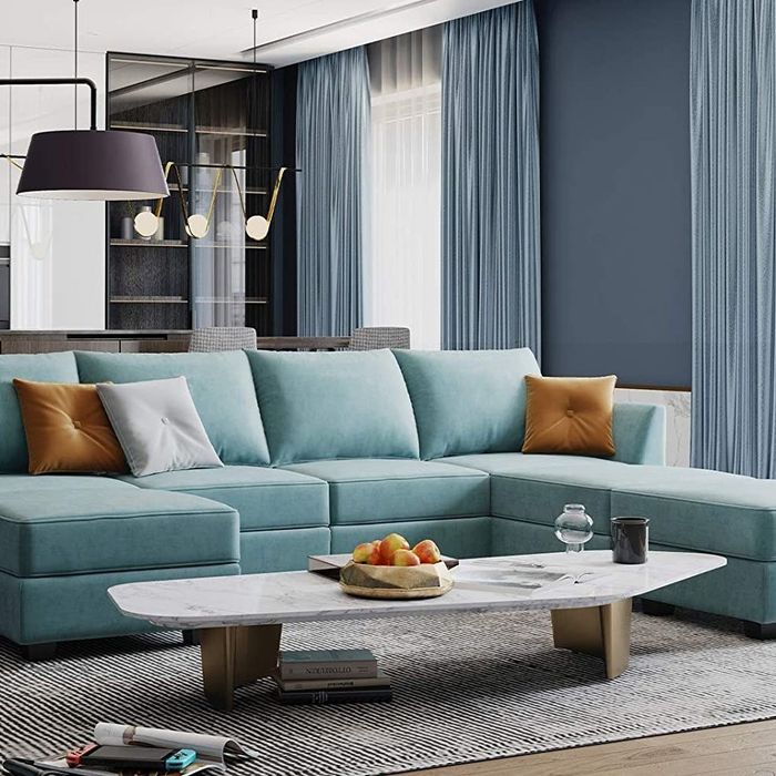 A teal U-shaped sectional is showcased in this cozy living room setting.