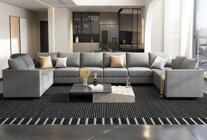 A large u-shaped gray sectional displayed in a loft-style setting