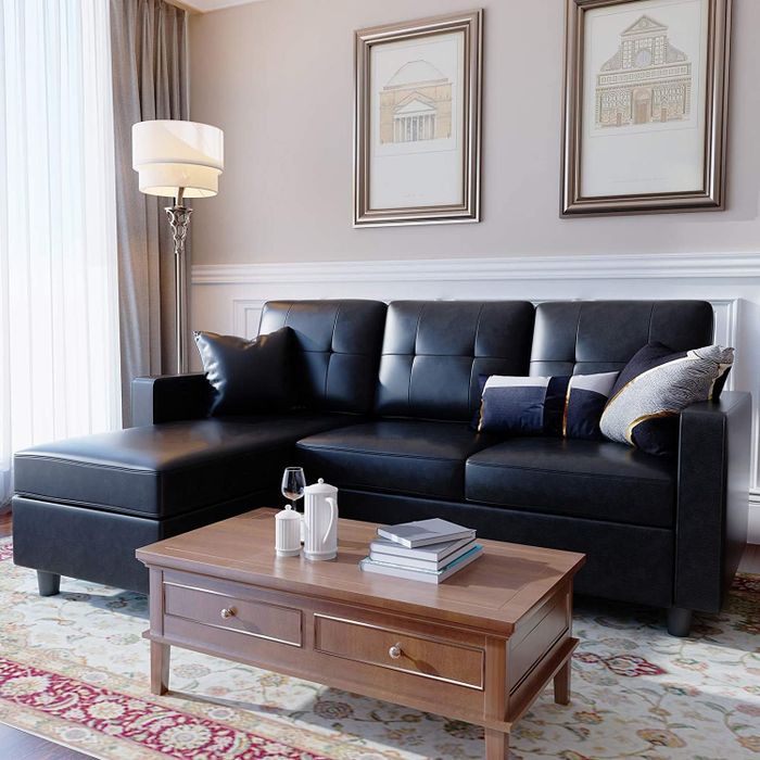 A black faux leather sectional sofa, offering sleek, modern design and comfort.