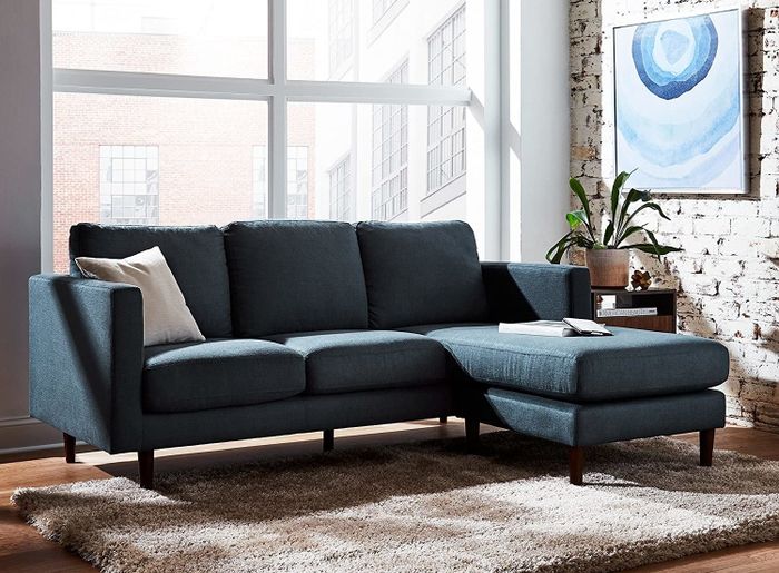A navy blue sectional displayed in a stylish living room setting