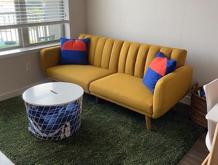 The reviewer’s mustard-colored sofa adds a pop of color to their space