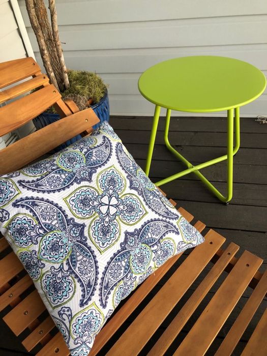 The green end table placed next to a reviewer's chaise lounge.