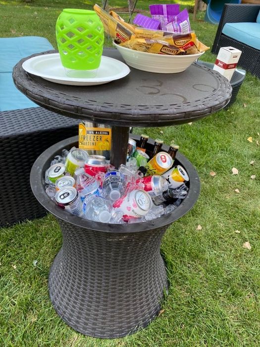 A high-top table extending from the cooler base, with food on the table and beverages and ice stored in the cooler section.