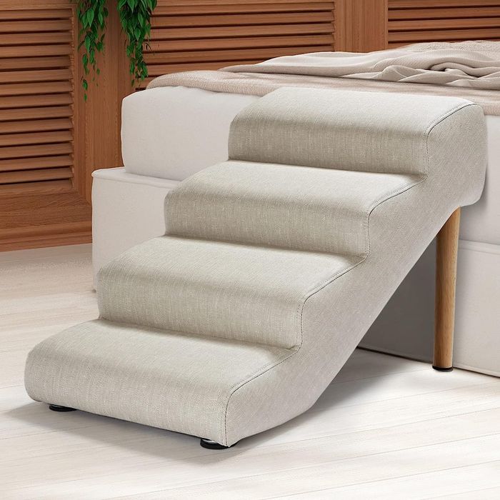 A set of dog stairs positioned up to a bed, giving your pup easy access.