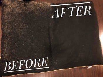 A photo from a reviewer showing a black pillow covered in white dog hair, with a clear contrast between the section brushed with the fur remover and the section still covered in dog hair