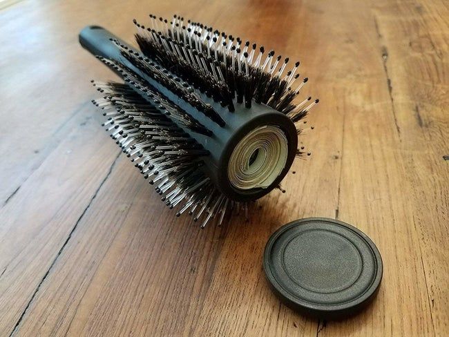 A round hairbrush with a hidden compartment inside to store cash