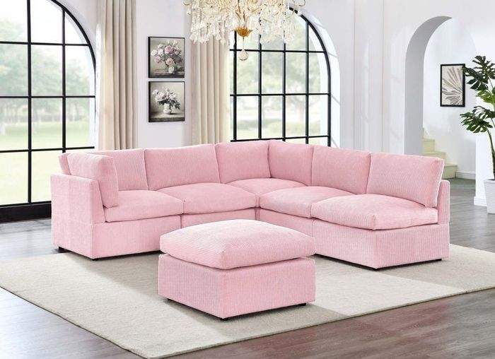 A chic pink sectional sofa with a matching ottoman, perfectly set in a bright and stylish living room.