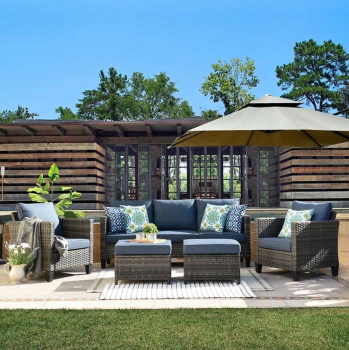 A navy and dark wicker seating set positioned on a beautifully designed patio, creating a welcoming space for outdoor relaxation and entertainment.