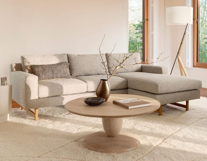 A beige linen sectional is displayed in an elegant living room setting.