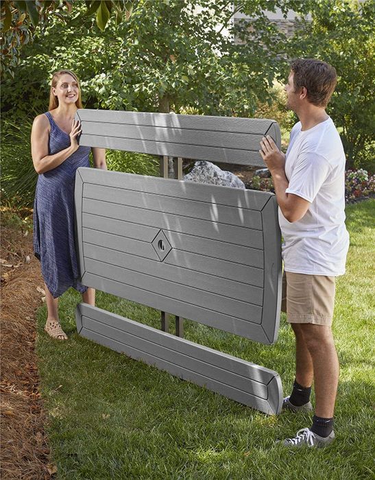 Two models holding a folded picnic table and benches, all completely flat.