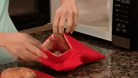 A gif showing hands placing a potato into a bag, microwaving it, and then removing the perfectly cooked potato from the bag.