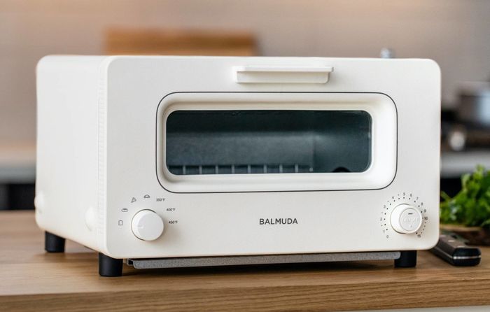 This white toaster features a single dial on the left side of the device, offering a sleek and simple control interface.
