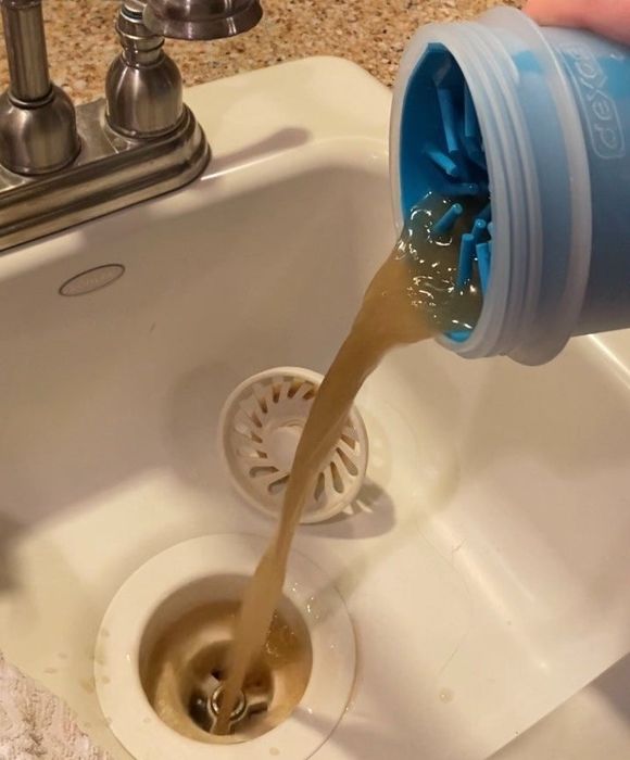 Another reviewer emptying the muddy, dirty water from the paw cleaner