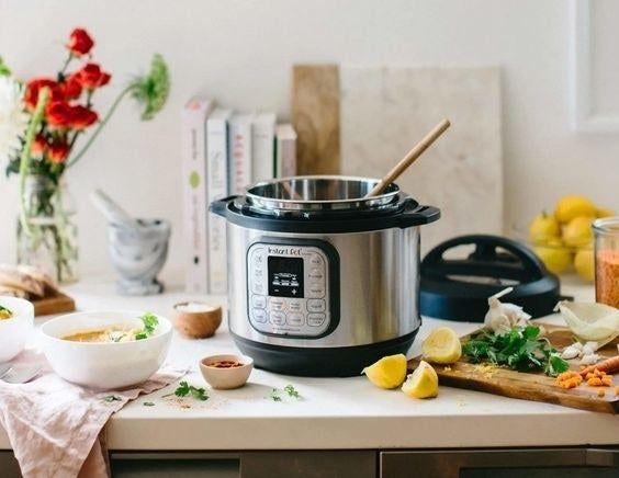 The silver Instant Pot appliance with 14 buttons/settings and a digital screen.