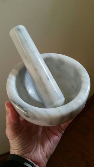 A reviewer holding the mortar and pestle, which is about the size of a typical bowl