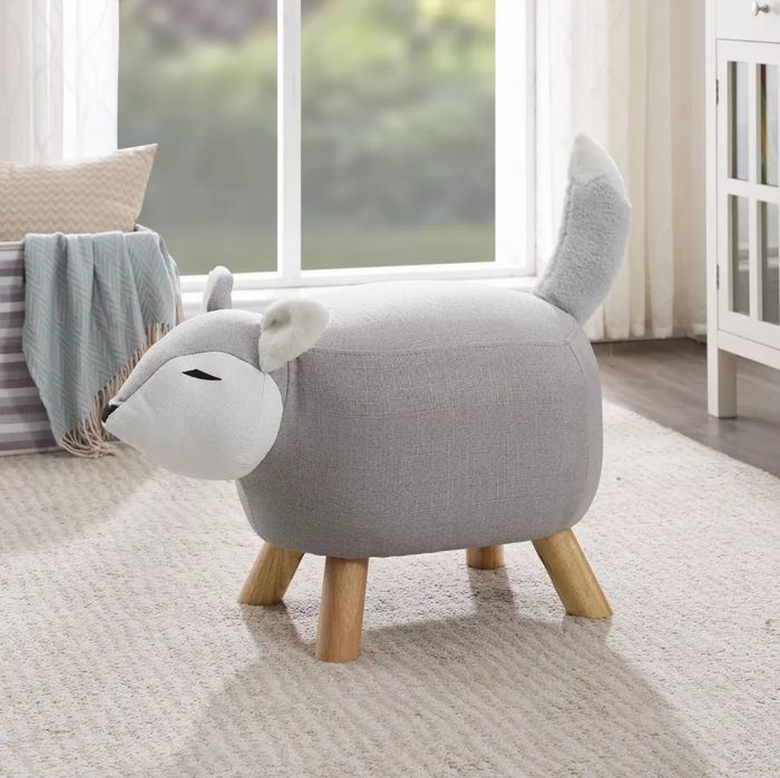 A plush fox stool with wooden legs, placed on a soft, low-pile rug.