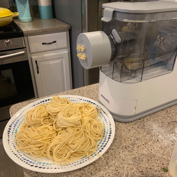A reviewer's pasta maker in action, preparing spaghetti.