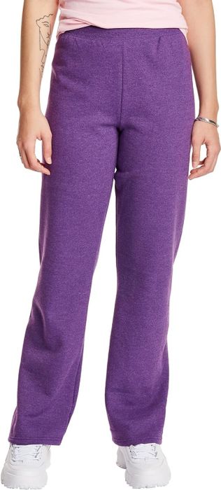A person rocks purple sweatpants and white sneakers, showing off a tattoo on their left arm.