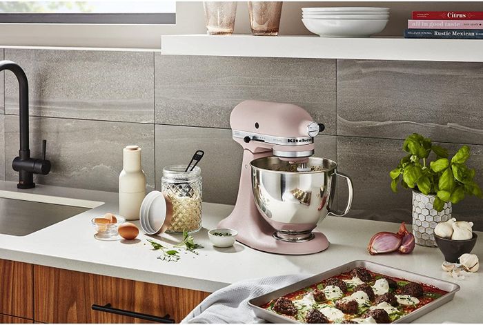A pink KitchenAid mixer elegantly sitting on a kitchen counter.