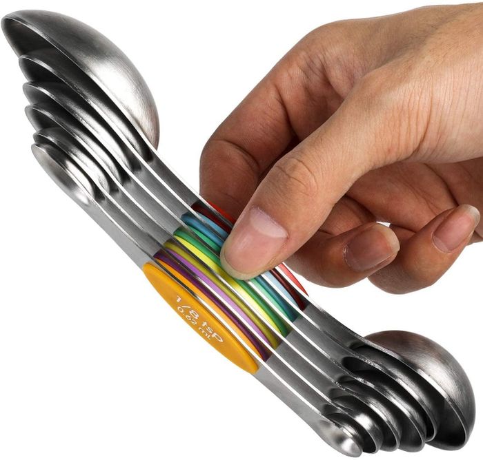 A reviewer holding the set, which sticks together magnetically