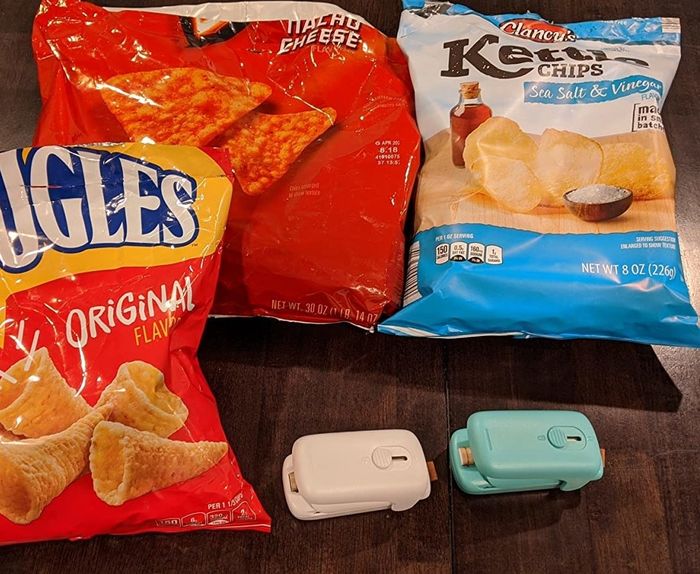 A reviewer's image of the blue and white sealers placed in front of several bags of chips
