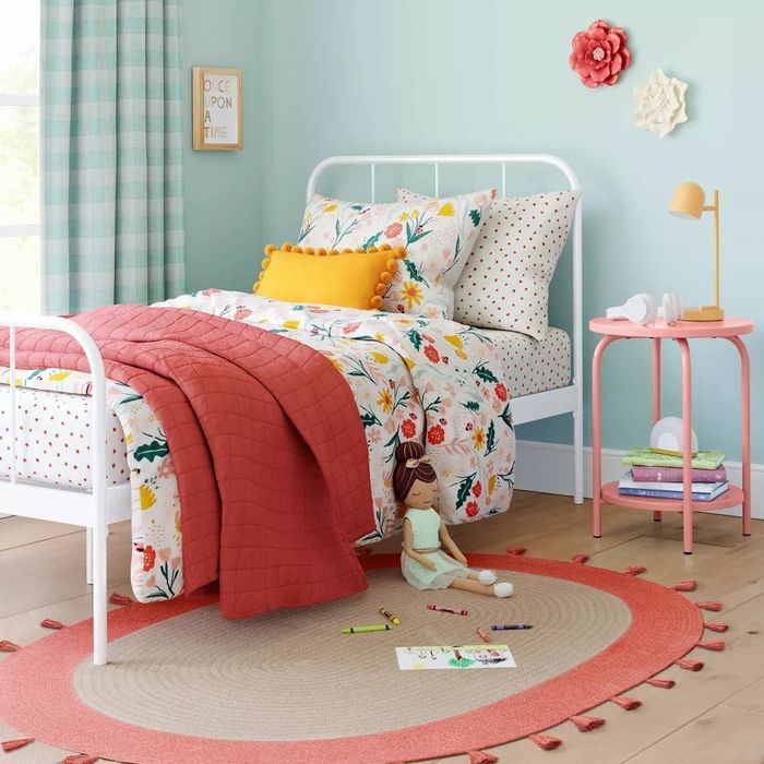 The pink nightstand placed next to a bed.