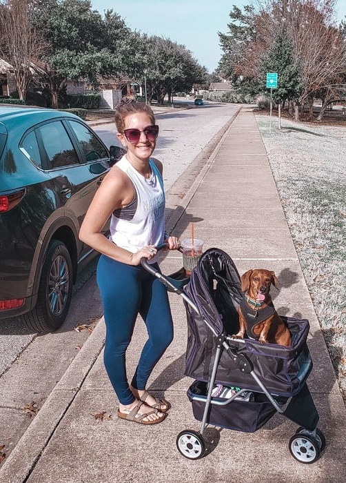A reviewer with their dog in a sleek black stroller