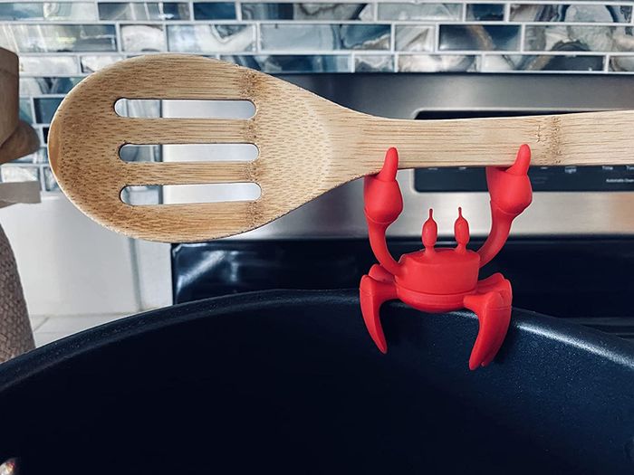 A close-up shot of a reviewer's crab utensil holder in use, keeping utensils in place while cooking.