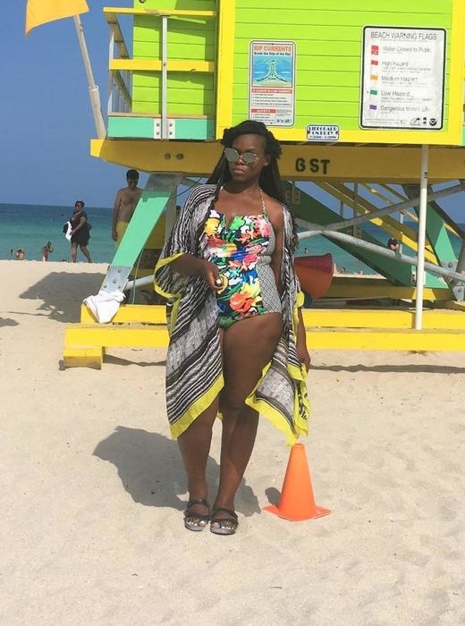 Another reviewer showing off the coverup in a black and white pattern with a yellow hem, layered over a swimsuit.