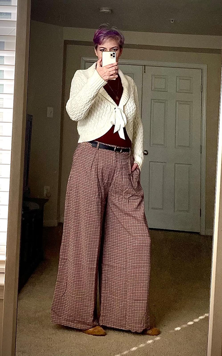 A reviewer showcasing the wide-leg pants in brown plaid.