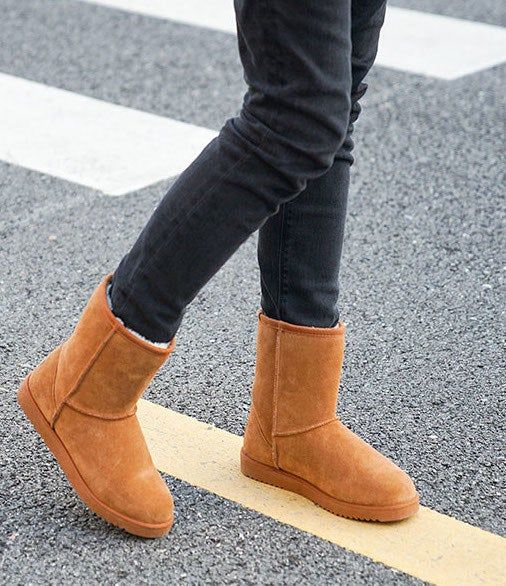 A model styles chestnut boots with black pants.