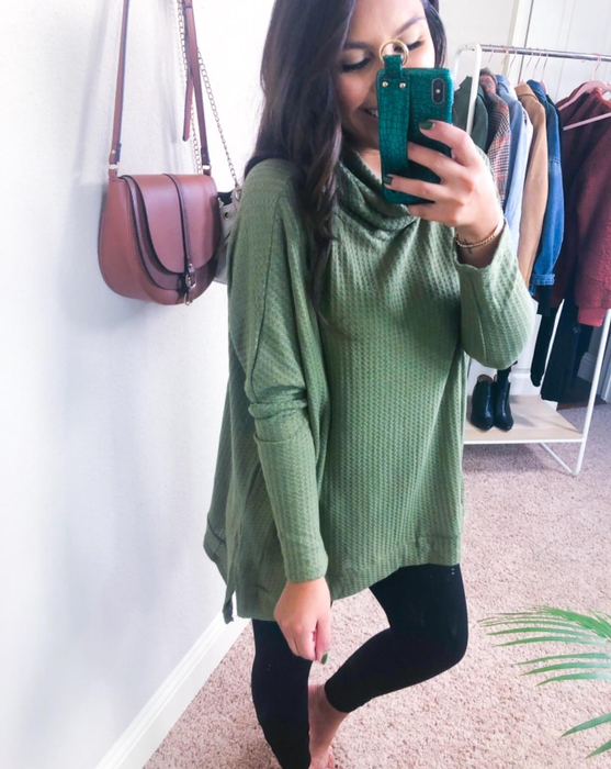 Another reviewer captures a mirror selfie in a green tunic top paired with black leggings.