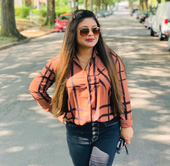 A reviewer is seen wearing the brown and black plaid button-down top.