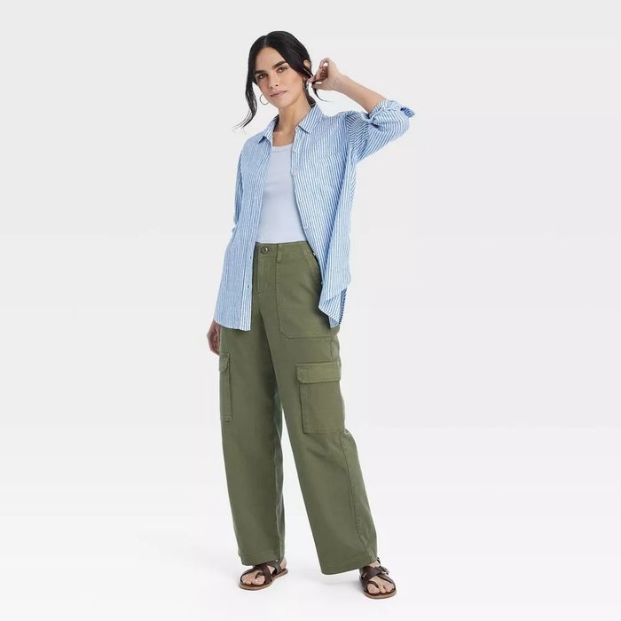A model dressed casually in a striped button-down shirt over a white top and wide-legged cargo pants.
