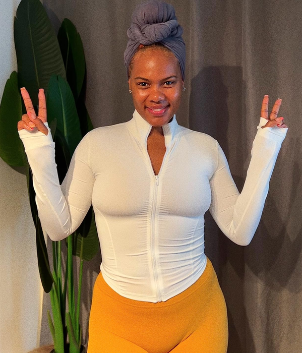 A reviewer poses while wearing the white jacket.