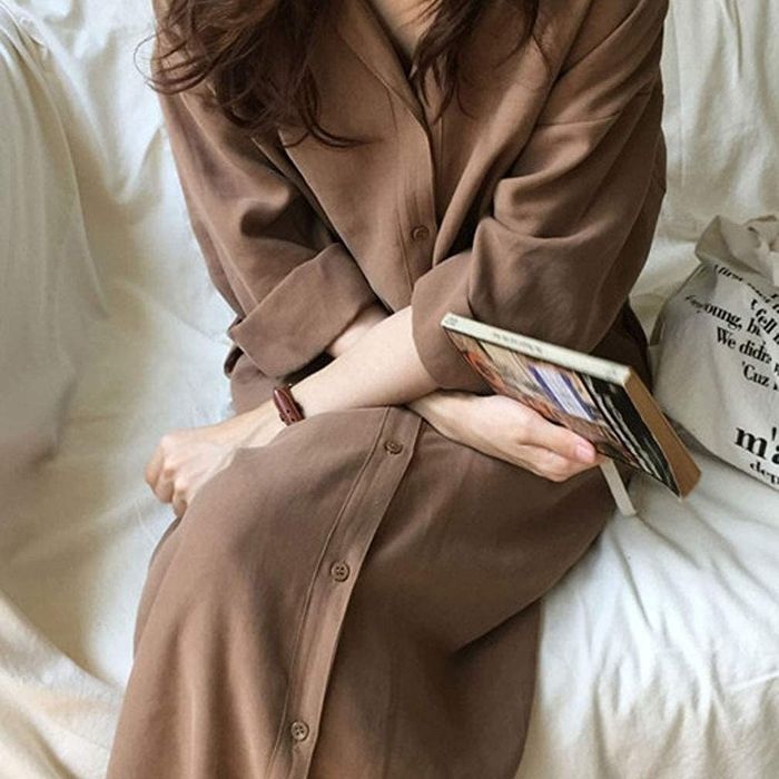 A reviewer is styled in the brown version of the collared dress.