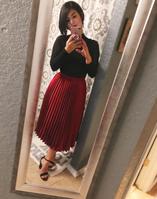 A reviewer showcasing the red satin skirt.