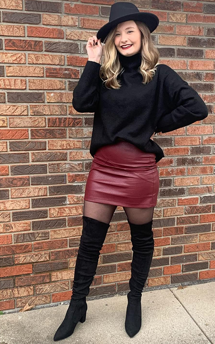 Another reviewer wears black over-the-knee boots, a burgundy skirt, black sweater, and a hat.
