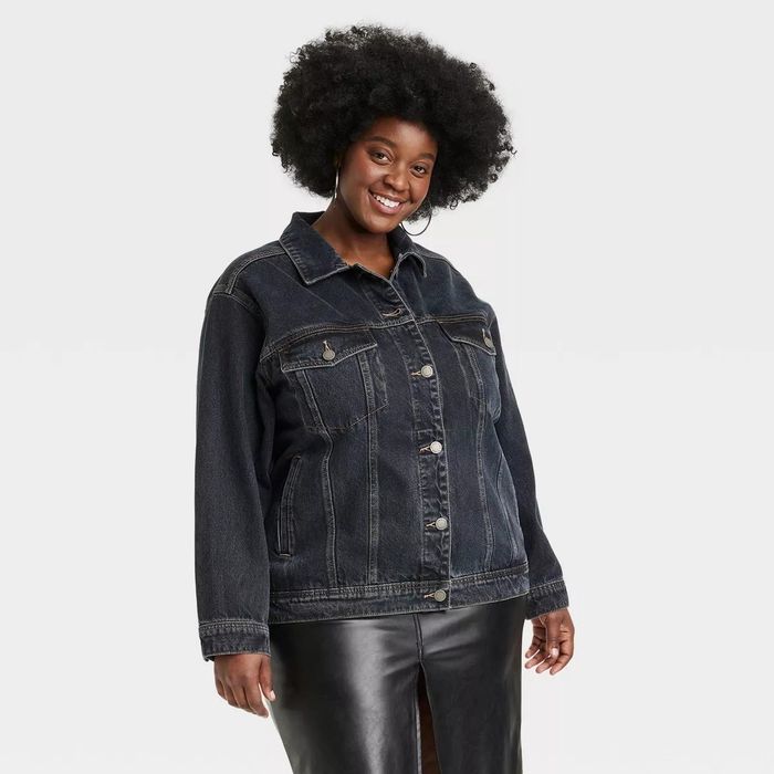 A model sporting a denim jacket paired with a leather skirt.