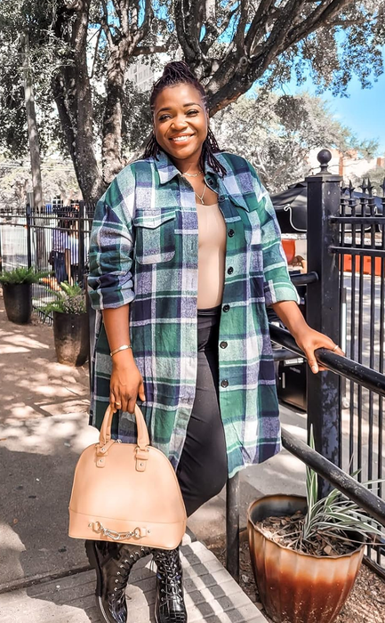 A reviewer strikes a pose in the green and blue flannel shirt.