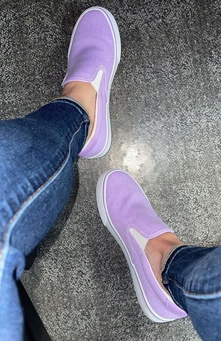 a reviewer wearing purple slip-on shoes