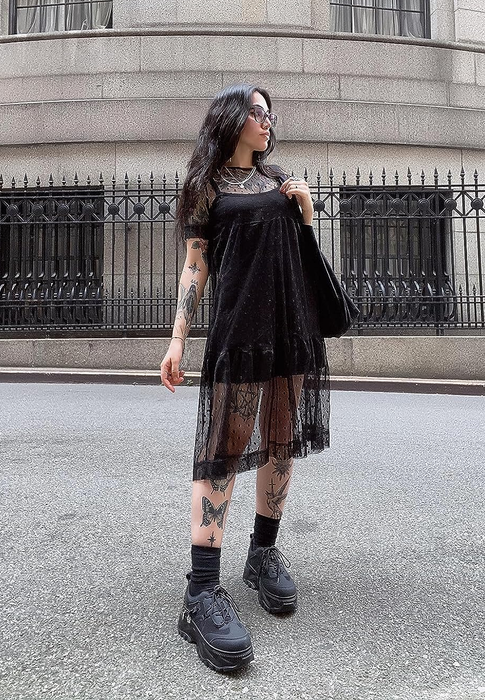 A reviewer models the organza cover-up dress with a mini black dress underneath.