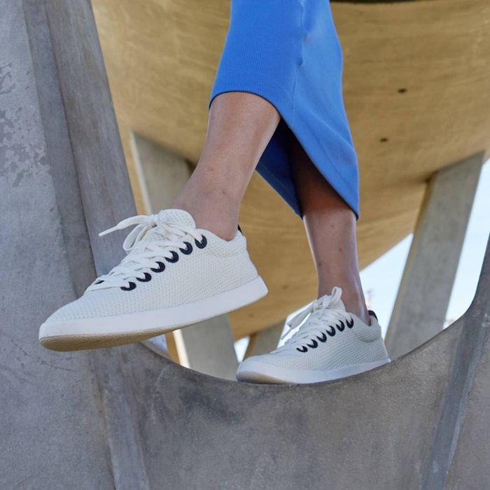 Model styled in white sneakers paired with a blue midi skirt