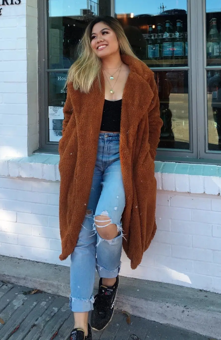 A reviewer showcasing the coat in brown