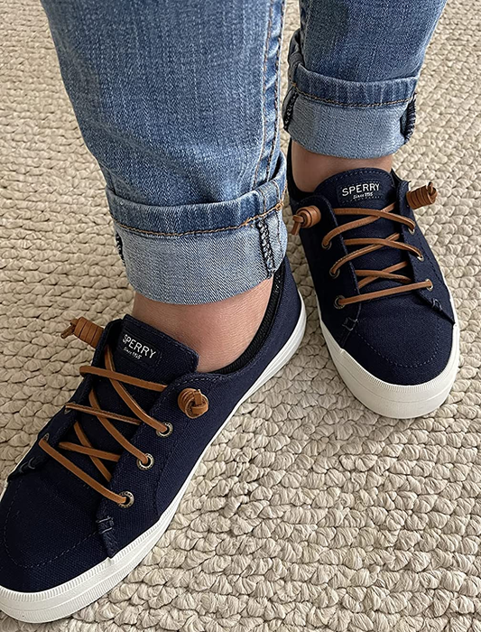 a reviewer’s feet in navy sneakers
