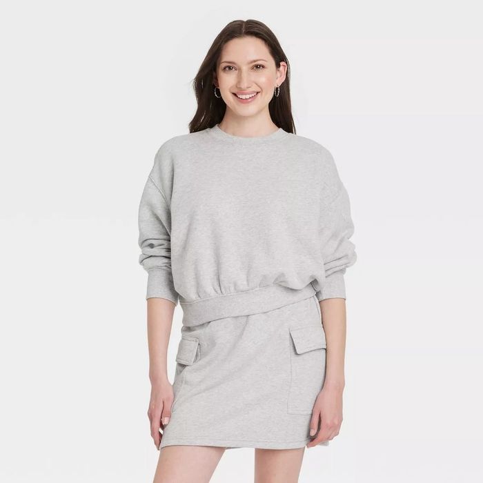 a person wearing the sweatshirt paired with a soft, plush skort