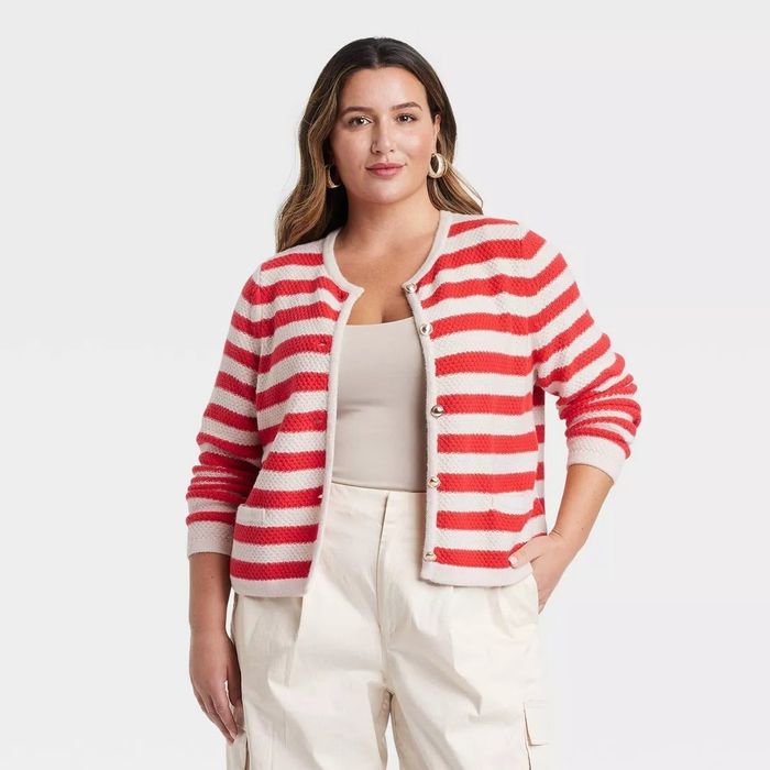 A person dressed in a striped cardigan and white cargo pants.