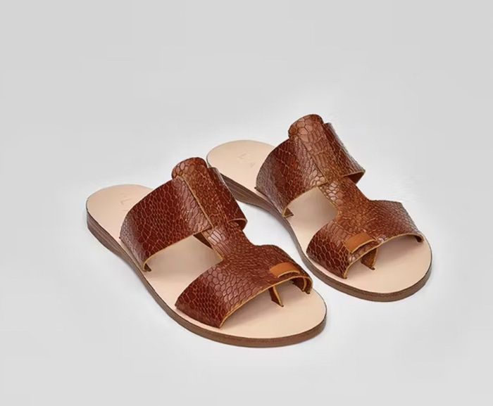 Close-up view of brown snakeskin leather sandals featuring a discreet toe slot